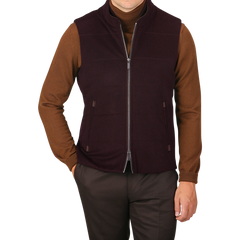 A person wearing a brown long-sleeve shirt, brown pants, and a Maurizio Baldassari Plum Water Repellent Cashmere Gilet poses against a plain background.