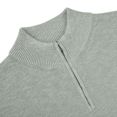 Maurizio Baldassari's Sage Green Summer Mouline 1/4 Zip Sweater features a sophisticated sage green knit with a short zipper from the collar against a black background, embodying relaxed luxury.