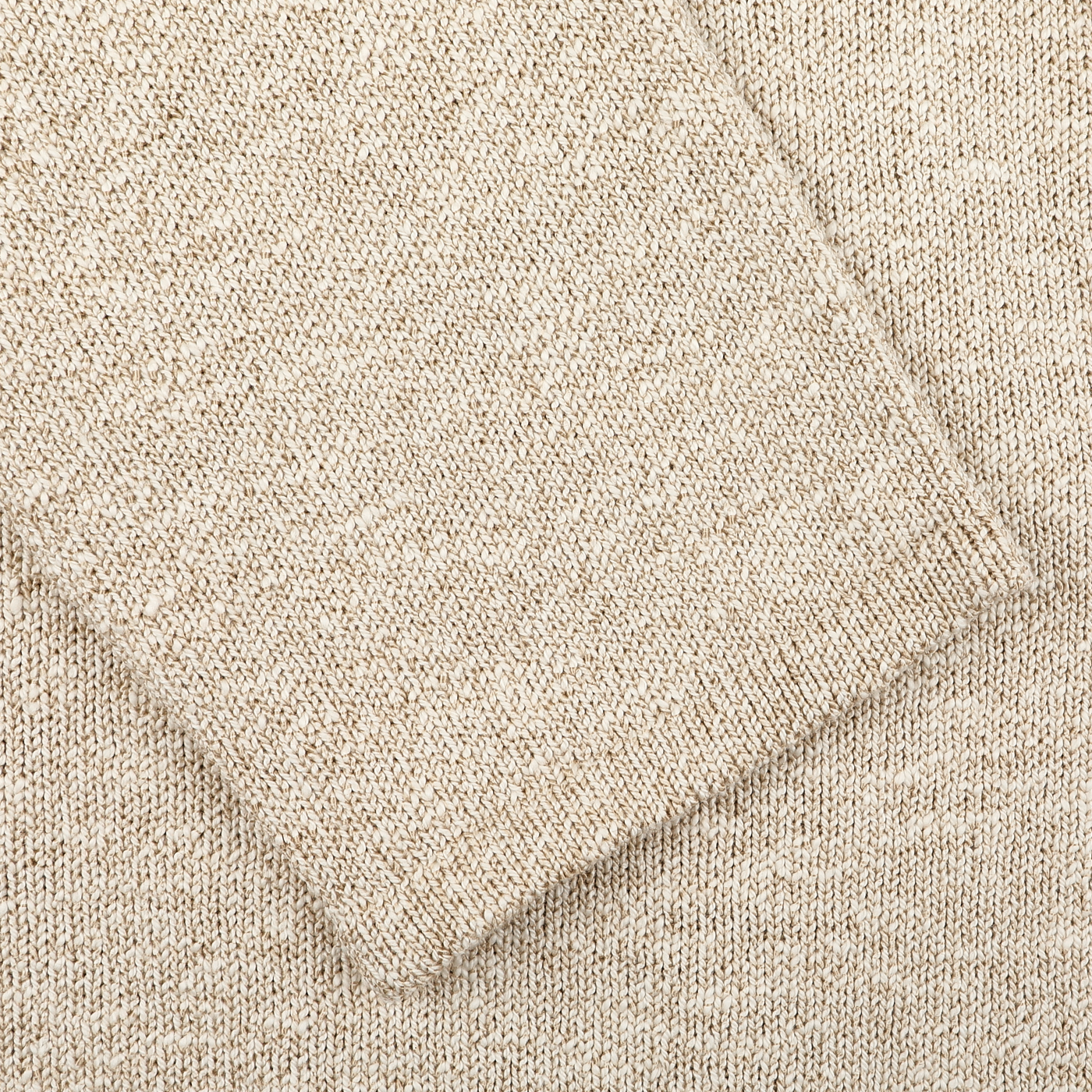 Close-up of a Sand Beige Summer Mouline Knitted Jacket by Maurizio Baldassari, highlighting its sleeve seam, crafted in a cotton-viscose blend for relaxed luxury.