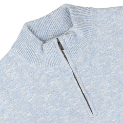 Close-up of the Sky Blue Winter Wool Mouline 1/4 Zip Sweater from Maurizio Baldassari, featuring a high collar and a 1/4-zip closure in the center. The zipper is partially open, revealing the inner Tasmanian wool fabric.