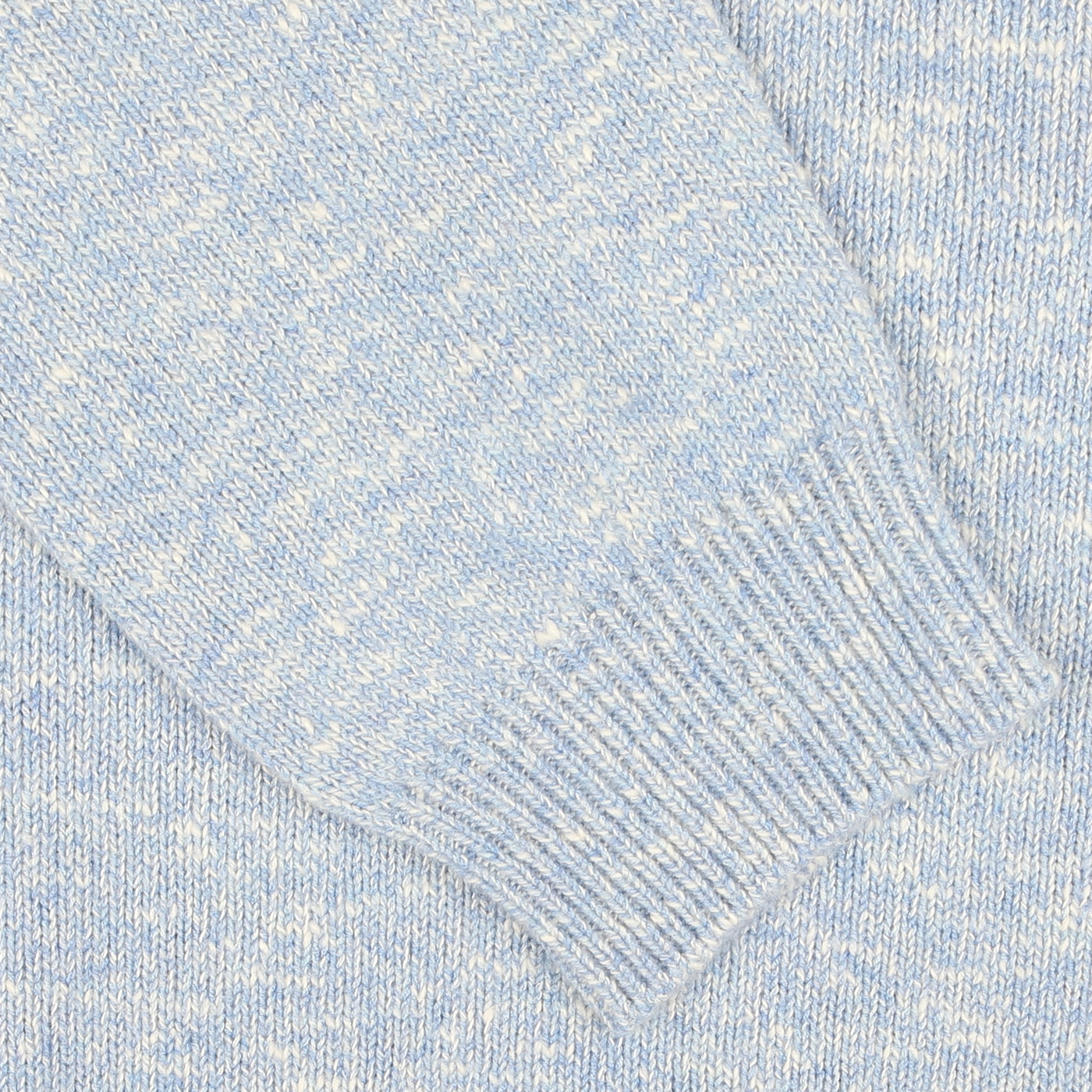 Close-up view of a sky blue melange knit fabric, showcasing the ribbed cuff of the Maurizio Baldassari Sky Blue Winter Wool Mouline 1/4-Zip Sweater.