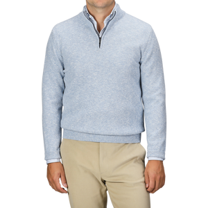 A person is shown from shoulders to waist, wearing a Sky Blue Winter Wool Mouline 1/4 Zip Sweater by Maurizio Baldassari and beige pants, against a plain background.