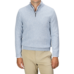 A person is shown from shoulders to waist, wearing a Sky Blue Winter Wool Mouline 1/4 Zip Sweater by Maurizio Baldassari and beige pants, against a plain background.