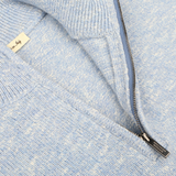 Close-up of a Sky Blue Winter Wool Mouline 1/4 Zip Sweater by Maurizio Baldassari, featuring a visible metal zipper and a fabric tag.