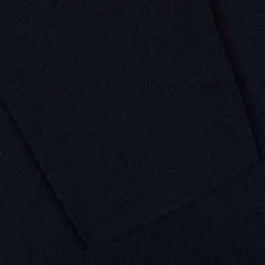 The Maurizio Baldassari Navy Blue Wool Milano Knitted Overshirt, crafted from pure virgin wool, showcases a dark blue fabric with a visible pocket or folded section.