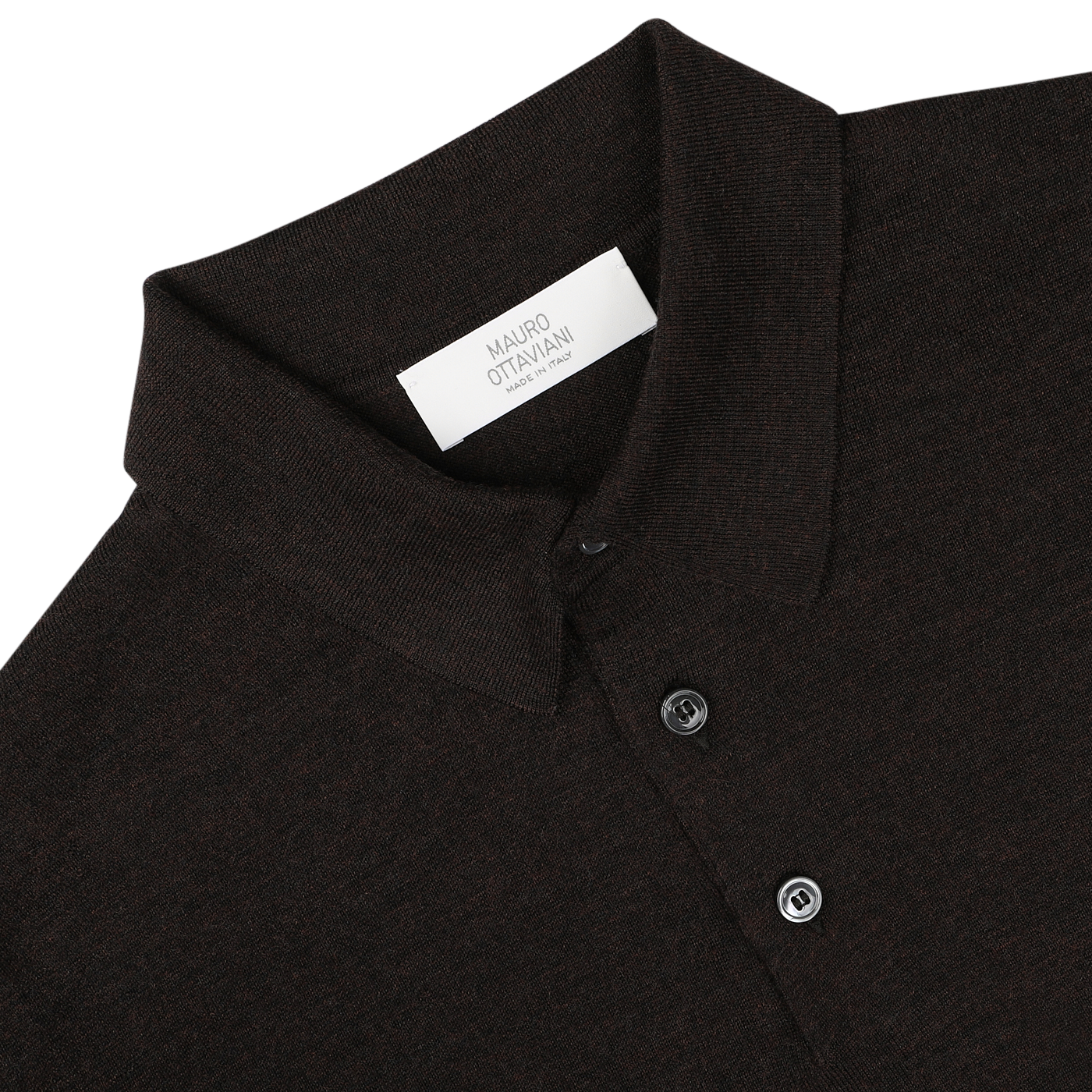 Close-up of a Mauro Ottaviani Brown Melange 16 Gauge Merino Wool Polo Shirt, featuring fine-knit long sleeves, a collar, and two buttons. A white label with text is visible inside the collar. The objects are set against a plain white background.