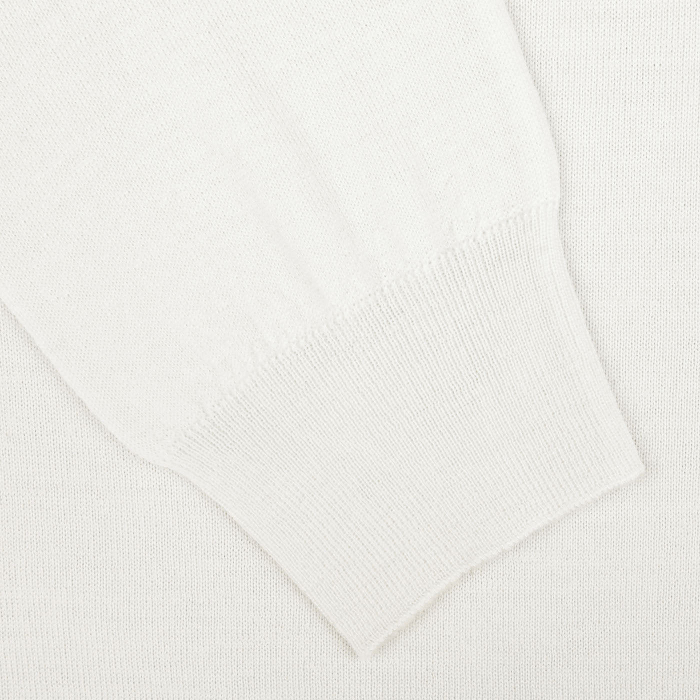 Close-up of a Cream 16 Gauge Merino Wool Polo Shirt sleeve from Mauro Ottaviani, crafted with pure merino wool, showcasing its ribbed cuff and smooth, soft texture.