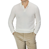 A person wearing a Mauro Ottaviani Cream 16 Gauge Merino Wool Polo Shirt and beige corduroy pants stands with their hands in their pockets against a plain background.