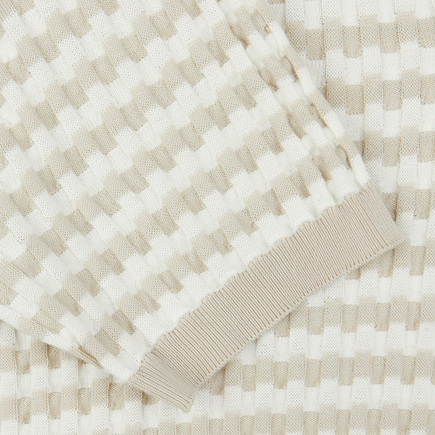 Close-up of a Cream Beige Cotton Rib-Knitted Polo Shirt from Mauro Ottaviani with a checkered pattern and a frayed edge.