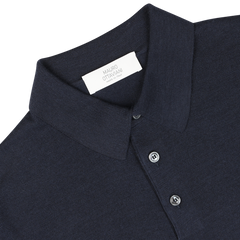 A close-up image of a Dark Blue 16 Gauge Merino Wool Polo Shirt with a white tag inside the collar that reads "Mauro Ottaviani." This shirt features long sleeves and buttons along the front, offering both style and comfort.