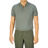 Man wearing a slim fit Mauro Ottaviani Khaki Green Supima Cotton Polo Shirt and green trousers against a gray background.
