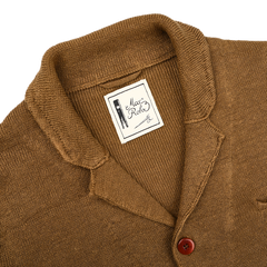 A tobacco brown linen Max 3 Chore Jacket by Max Rohr, complete with a shawl collar and a single visible button, exudes sartorial elegance.