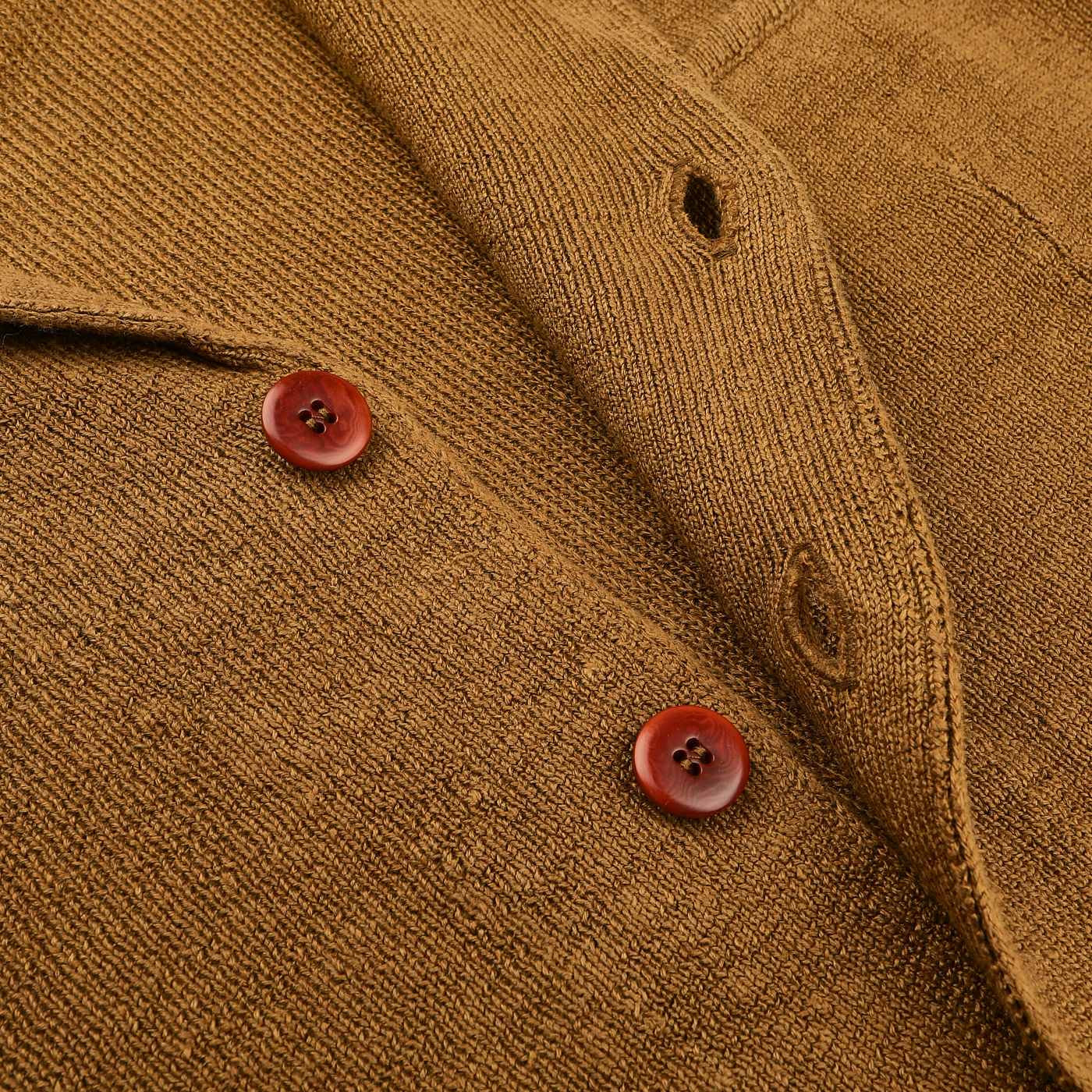 The Tobacco Brown Linen Max 3 Chore Jacket by Max Rohr exudes sartorial elegance, featuring two red buttons with vertically aligned buttonholes on its finely knitted fabric.