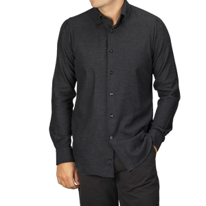 A person wearing a Charcoal Grey Brushed Cotton Twill BD Slim Shirt by Mazzarelli stands with hands in pants pockets against a neutral background.