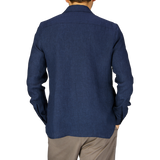 A man viewed from behind wearing a Mazzarelli Dark Blue Organic Linen Overshirt and khaki trousers against a grey background.