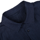 Close-up view of a Mazzarelli Dark Blue Organic Linen Overshirt collar with a button, made in Italy.