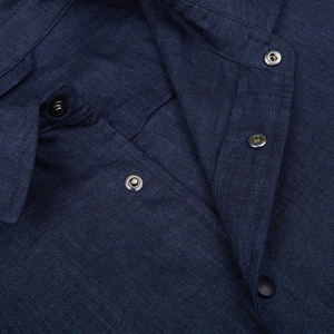 A close-up view of a Dark Blue Organic Linen Overshirt's collar and top button, made in Italy by Mazzarelli.