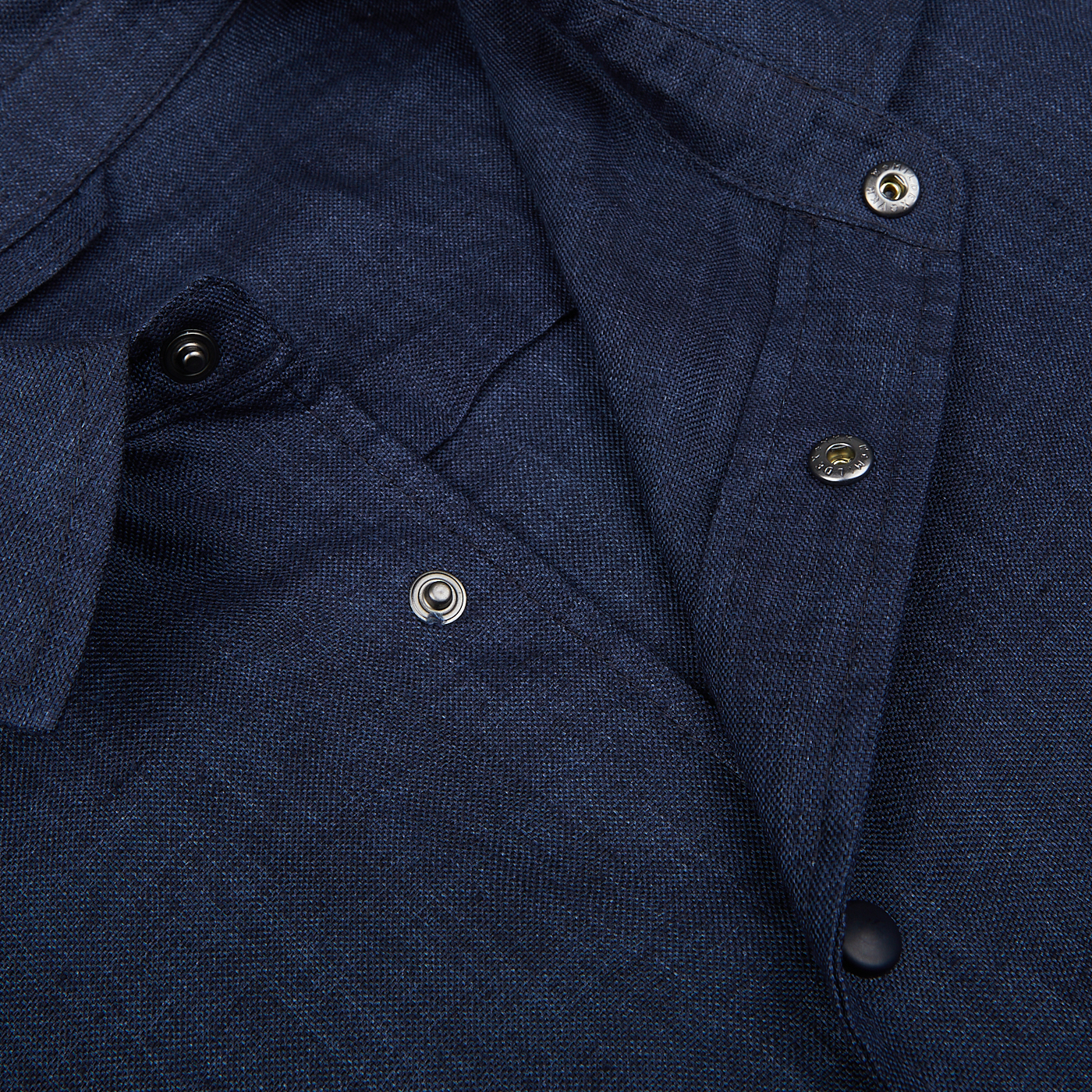A close-up view of a Dark Blue Organic Linen Overshirt's collar and top button, made in Italy by Mazzarelli.