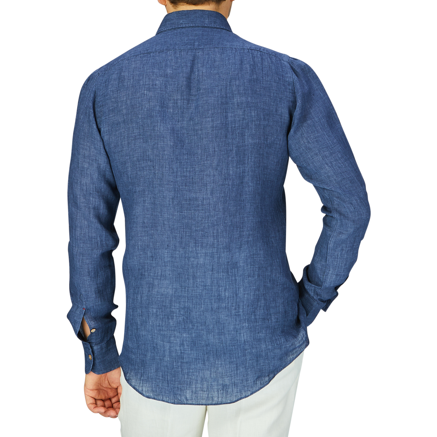 A person standing with their back facing the camera, wearing a white pants and an indigo blue organic linen BD slim shirt by Italian shirtmaker Mazzarelli.