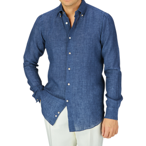 A man wearing an Indigo Blue Organic Linen BD Slim Shirt by Italian shirtmaker Mazzarelli and white pants.