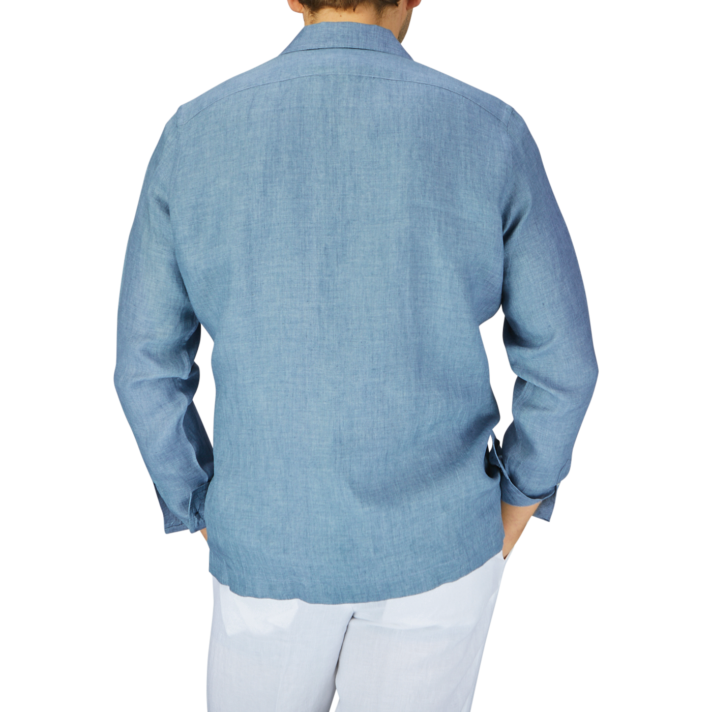 Rear view of a person wearing a Mazzarelli Indigo Blue Organic Linen Four Pocket Overshirt and white pants, standing against a plain light gray background.