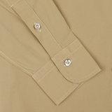 Khaki Beige Cotton Gabardine Regular Fit Shirt sleeve with decorative skull buttons on a matching background, crafted by Italian shirtmaker Mazzarelli.