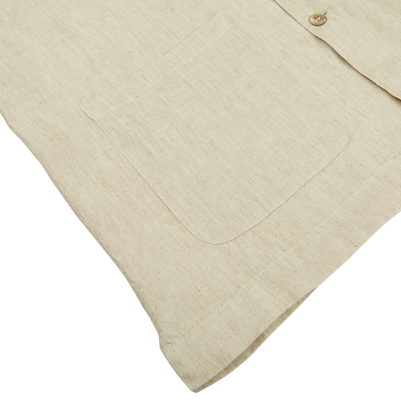 Close-up of a Mazzarelli Khaki Beige Organic Linen Four Pocket Overshirt with a detailed view of the texture, pocket, and a button.