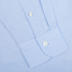 Close-up of the sleeve of the Mazzarelli Light Blue Brushed Cotton Twill BD Slim Shirt, featuring white buttons on a cuffed end with a stripe pattern, expertly laid flat.