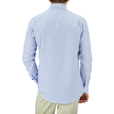 Man standing with his back to the camera wearing a Light Blue White Striped Cotton BD Slim Shirt by Mazzarelli and light green pants.