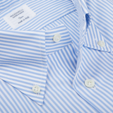 Close-up view of a light blue and white Bengal striped shirt with a label showing “Mazzarelli - Made in Italy” on the collar.