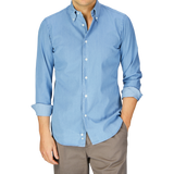 Man wearing a light blue denim shirt by Italian shirtmaker Mazzarelli and grey pants. 

Revised Sentence: Man wearing a Light Denim Washed Cotton BD Regular Fit Shirt by Italian shirtmaker Mazzarelli and grey pants.