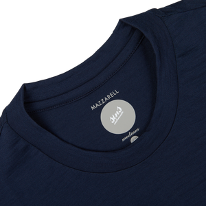 Close-up of a Navy Blue Merino Wool T-shirt's label showing the brand "Mazzarelli" in a medium, slim fit size, set against a white background.