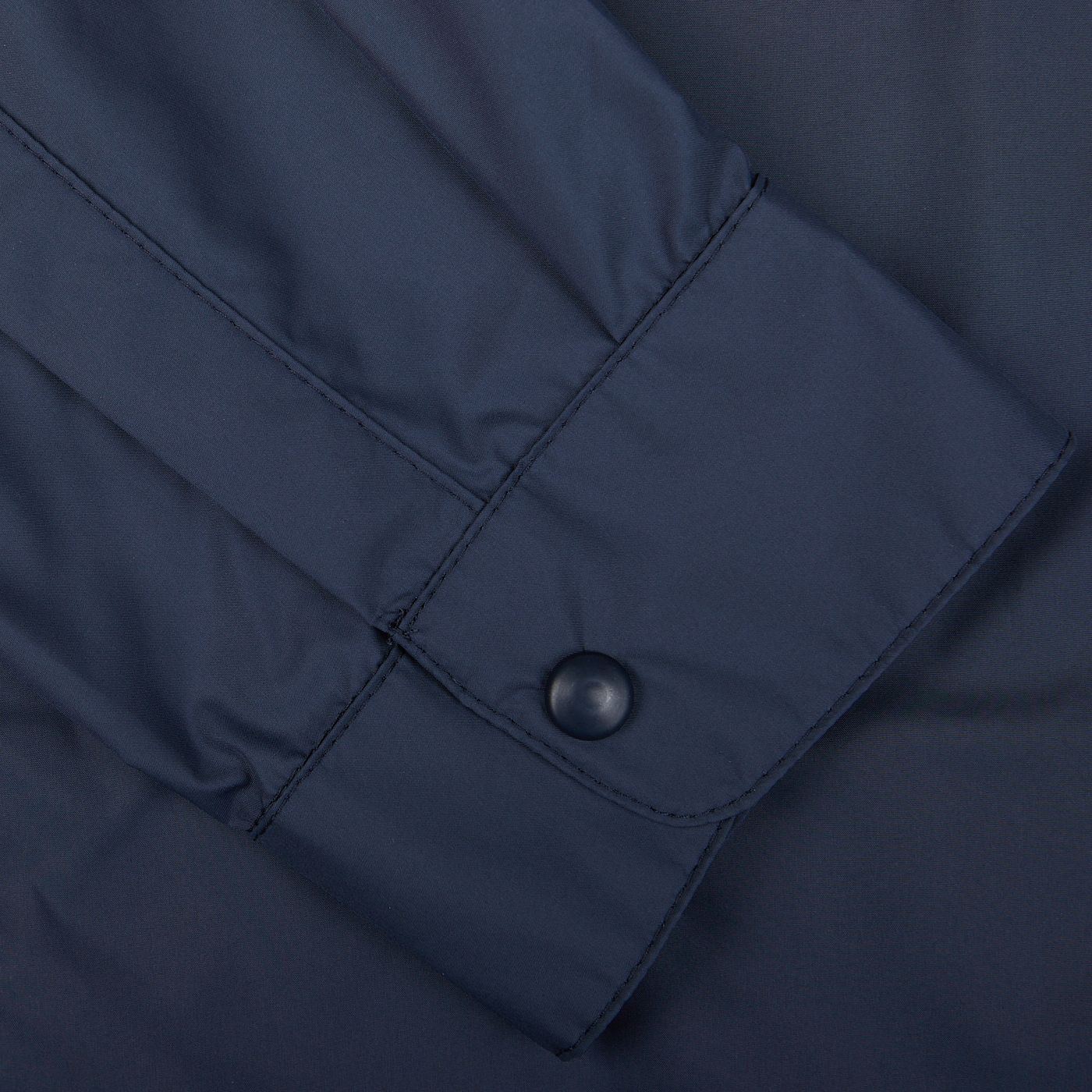 Close-up of a Mazzarelli navy blue nylon water resistant overshirt sleeve with a button closure.