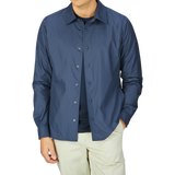 A man wearing a Mazzarelli navy blue nylon water resistant overshirt and cream trousers.