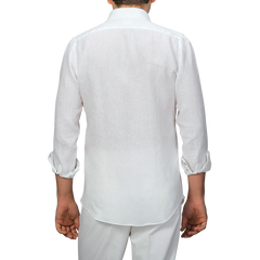 A person is seen from behind wearing an Off-White Organic Linen BD Shirt by Mazzarelli, featuring rolled sleeves and a button-down collar, paired with white pants.