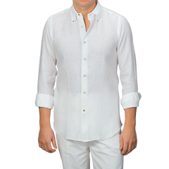 A person wearing an Off-White Organic Linen BD Shirt by Mazzarelli with rolled-up sleeves, paired with white pants.