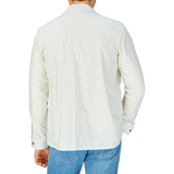 Man wearing a white shirt and blue jeans viewed from behind, covered by a slim fit Off-White Nylon Water Resistant Overshirt by Mazzarelli.