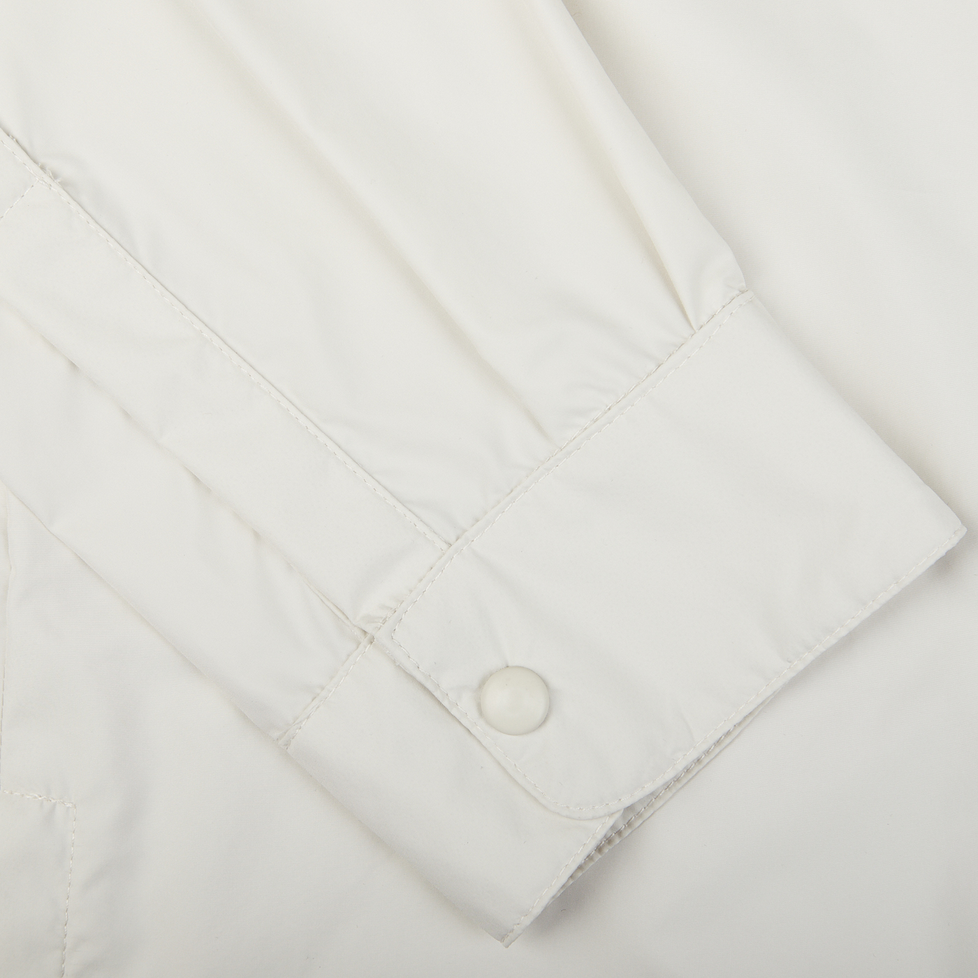 Close-up of a Mazzarelli Off-White Nylon Water Resistant Overshirt cuff with a button.