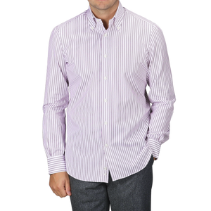 Dressed in a Mazzarelli Purple Double Striped Cotton BD Regular Shirt, featuring a soft button-down collar and hand-stitched pleated shoulder, the person paired it perfectly with grey pants, hands casually tucked in their pockets.