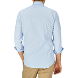 A man seen from behind wearing a Sky Blue Cotton Gabardine Regular Fit Shirt by Mazzarelli and beige pants.