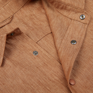 Close-up of a Terracotta Brown Organic Linen Overshirt from Mazzarelli with buttons and a collar, crafted from organic linen fabric.
