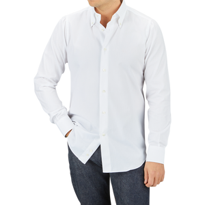 Man wearing a Mazzarelli White Royal Oxford BD Slim Shirt and dark jeans standing against a gray background.