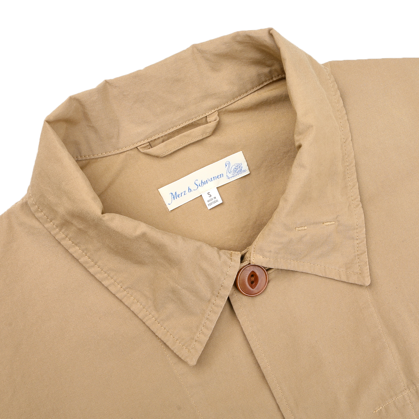 Khaki Beige Cotton Poplin 02 Jacket with a collared design and buttoned neck, featuring vegan corozo buttons and the Merz b. Schwanen label inside the collar indicating brand and size.