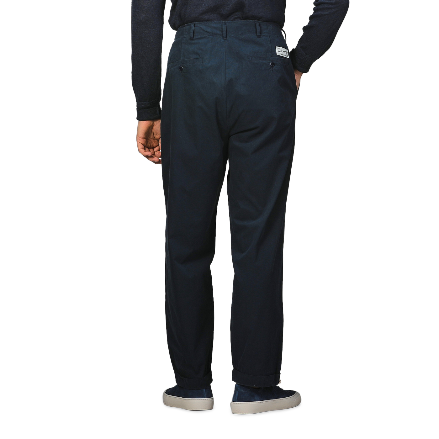 A person is seen from behind, hands in pockets, wearing Merz b. Schwanen’s Navy Blue Cotton Poplin 03 Pants and a dark organic cotton long-sleeve shirt.