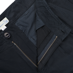 Close-up of a pair of Navy Blue Cotton Poplin 03 Pants from Merz b. Schwanen, unzipped to show the button and waistband with a visible label, highlighting their comfort and versatility.