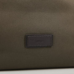 Close-up of a dark brown fabric bag with a small rectangular black label that reads "Mismo.