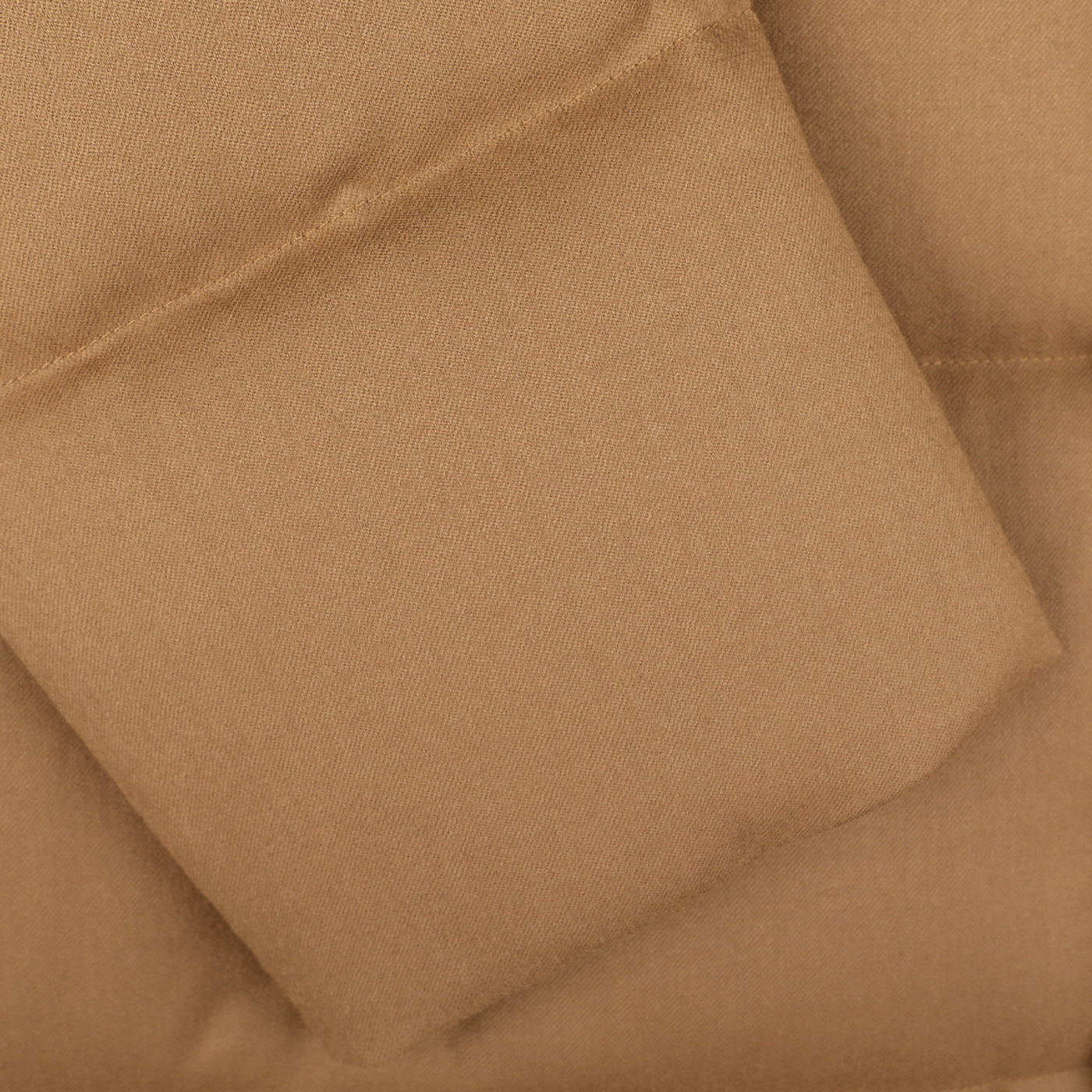 Close-up of a brown padded fabric with a pocket stitched onto it, likely part of the Montecore Camel Beige VBC Wool Flannel Padded Parka.