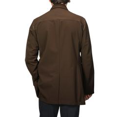 A man wearing the Dark Brown Aéro Twill Car Coat by Montecore exudes sophistication, reminiscent of sleek Italian outerwear.