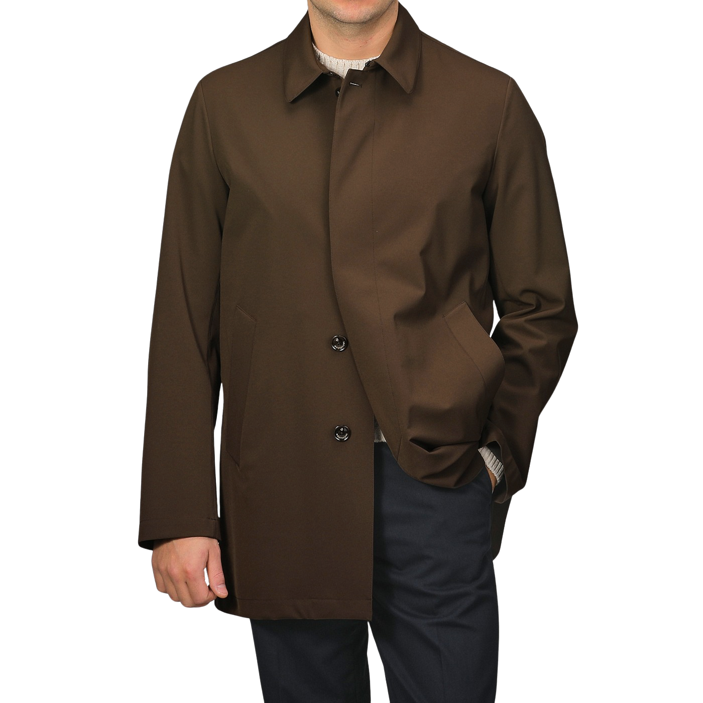 A man wearing a Montecore Dark Brown Aéro Twill Car Coat, hand in pocket, paired with dark pants against a plain background.