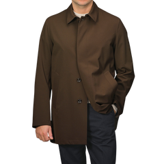 A man wearing a Montecore Dark Brown Aéro Twill Car Coat, hand in pocket, paired with dark pants against a plain background.